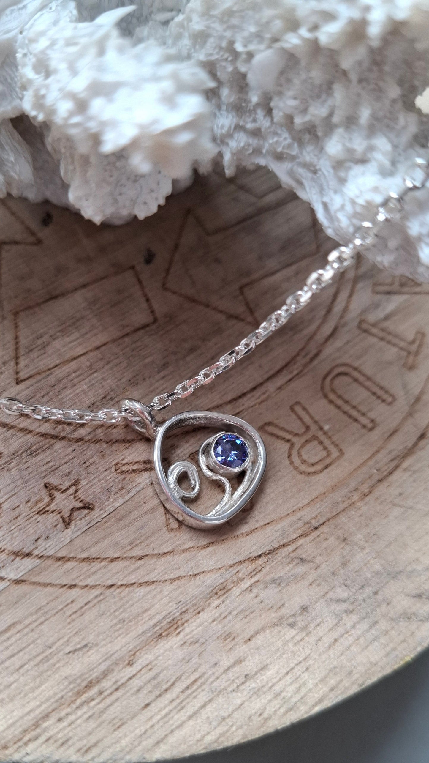 This silver and tanzanite cubic zirconia pebble shaped wave pendant is inspired by the stunning Mediterranean seas.