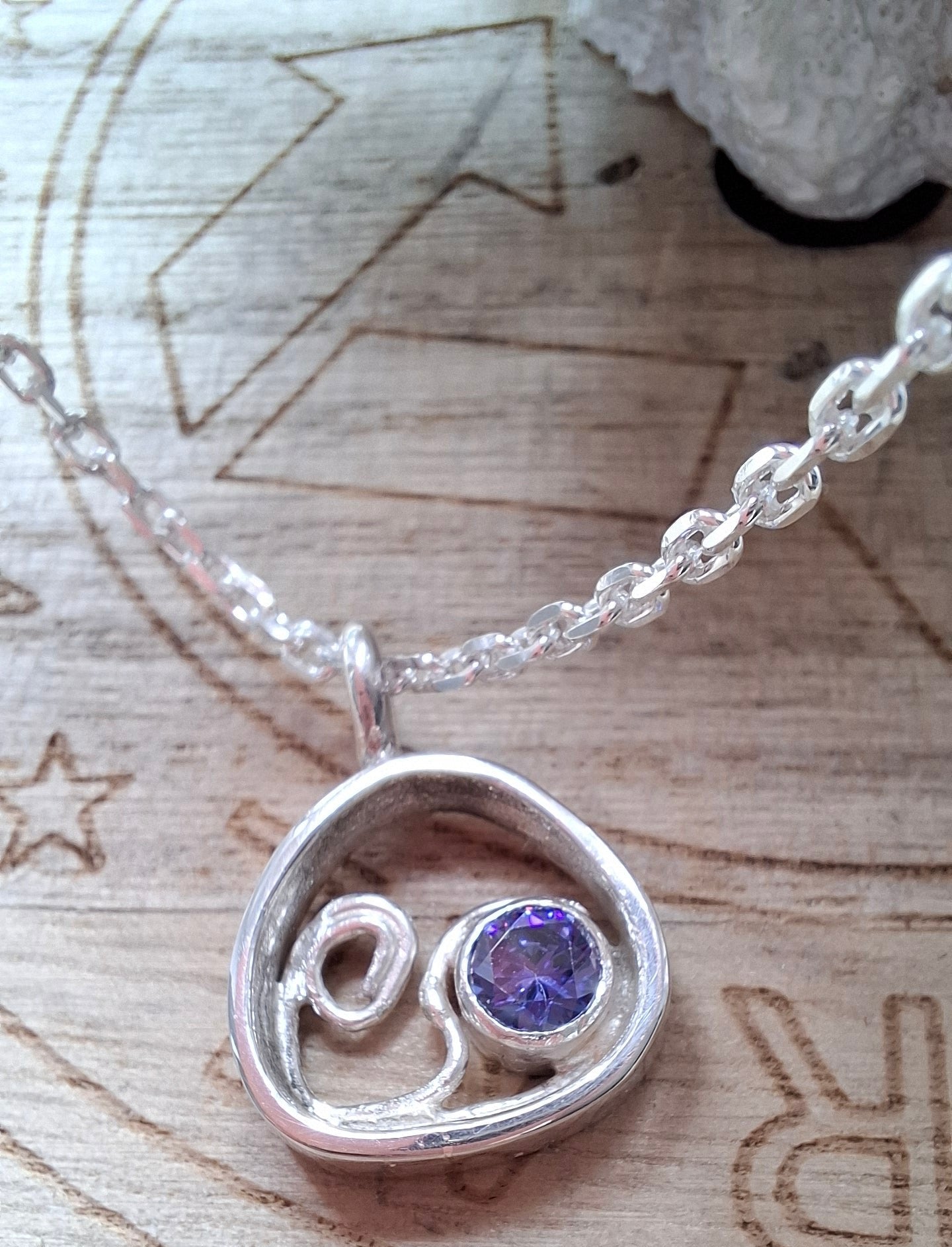 This silver and tanzanite cubic zirconia pebble shaped wave pendant is inspired by the stunning Mediterranean seas.