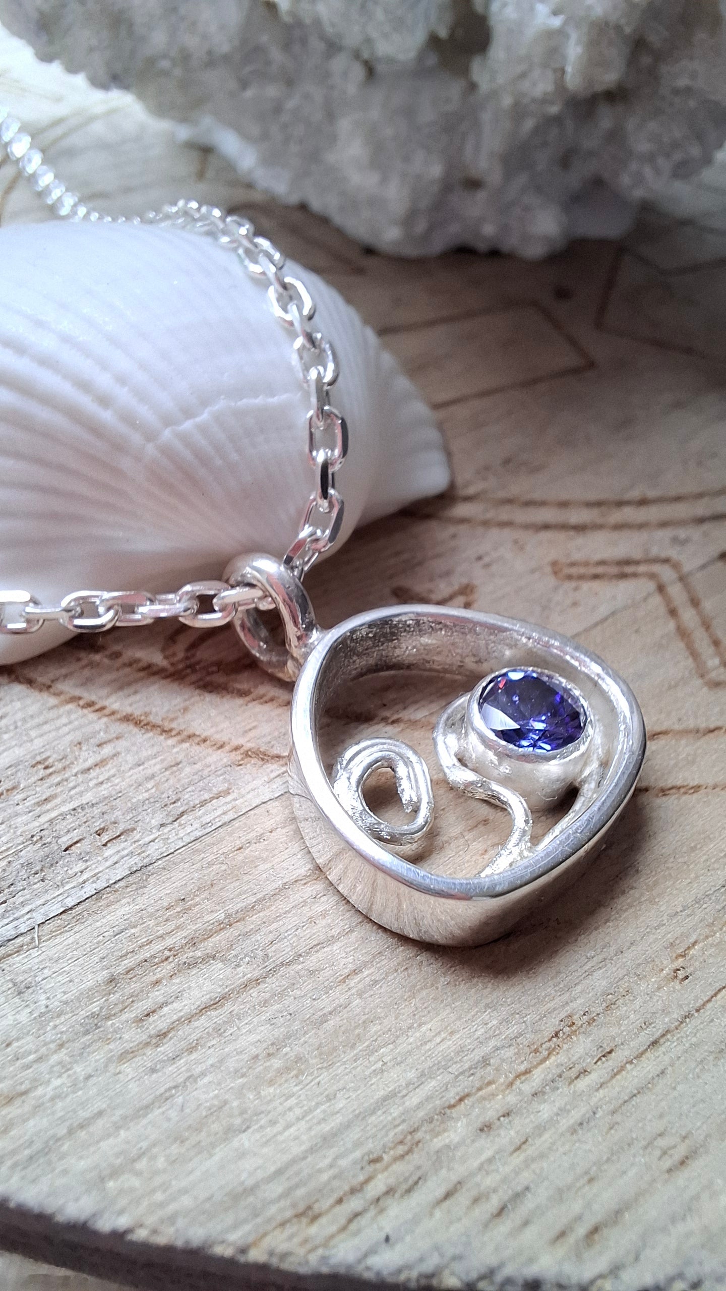 This silver and tanzanite cubic zirconia pebble shaped wave pendant is inspired by the stunning Mediterranean seas.