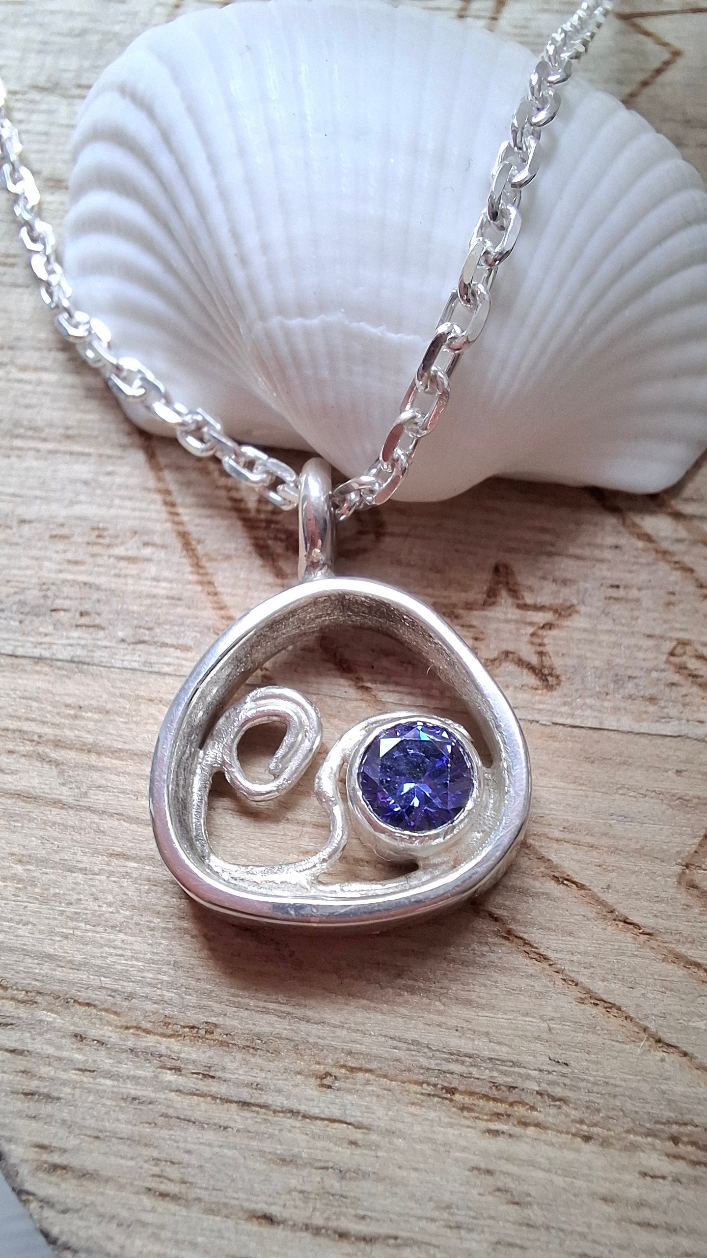 This silver and tanzanite cubic zirconia pebble shaped wave pendant is inspired by the stunning Mediterranean seas.