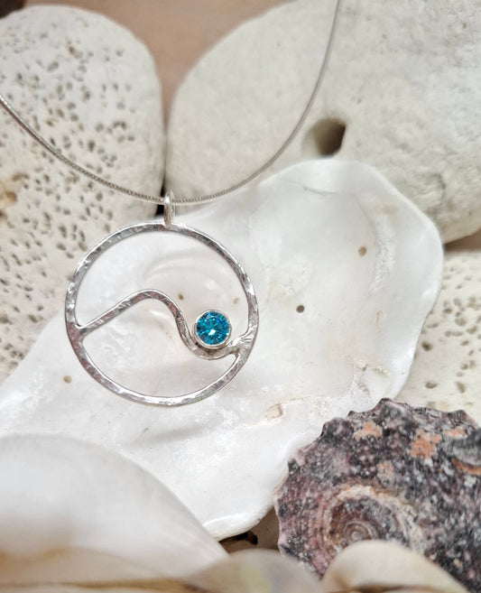 Hammered circle wave pendant with aquamarine cubic zirconia