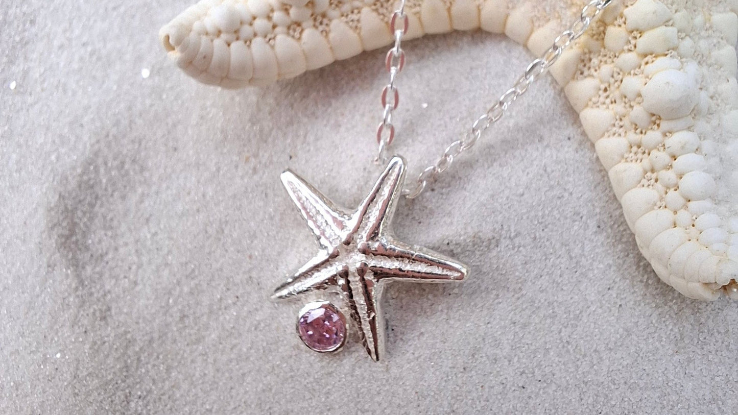 Cast silver starfish pendant with a vibrant cubic zirconia, with necklace