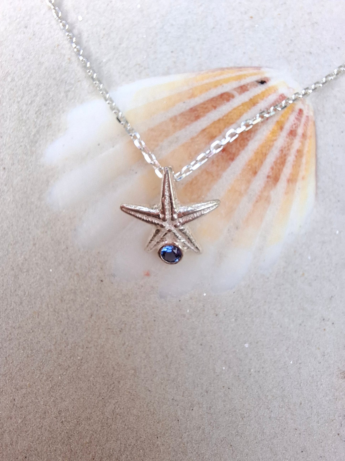 Cast silver starfish pendant with a vibrant cubic zirconia, with necklace