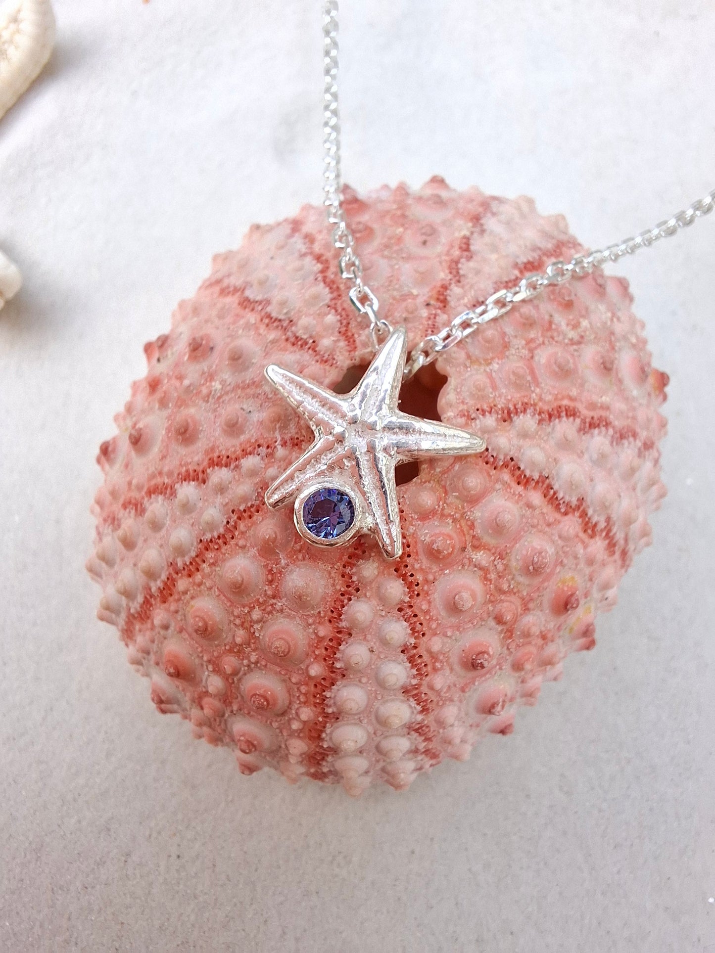 Cast silver starfish pendant with a vibrant cubic zirconia, with necklace